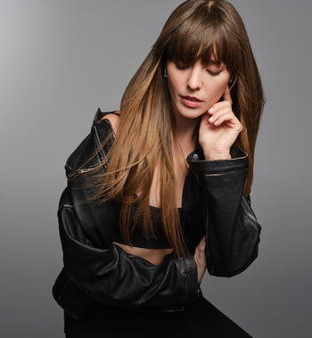 Woman wearing a black leather jacket against a gray background